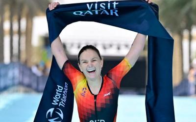 Athletin hält Zielbanner in der Hand bei T100-AK-WM in Qatar