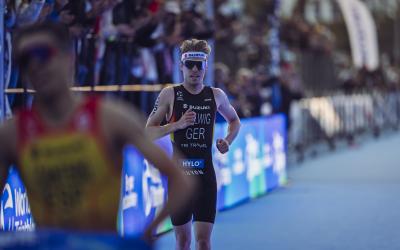 Ein Triathlet läuft über den Zielteppich ins Ziel eines Rennens