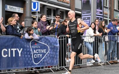 Lasse Lührs läuft im Deutschland-Einteiler an einer ganzen Reihe von zuschauern vorbei, die hinter der Absperrung gebannt zusehen und anfeuern