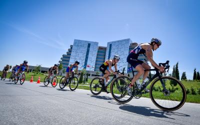 Mehrere Triathletinnen fahren auf einer Straße zusammen hintereinander Rad