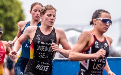 Eine deutsche Triathletin läuft gemeinsam mit zwei anderen Triathletinnen im Regen