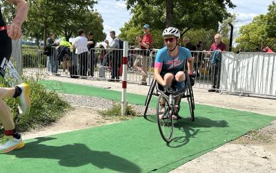Eine Para Triathletin im Rollstuhl fährt eine Rechtskurve