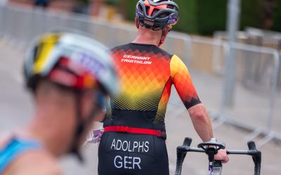 Athlet im Deutschlanddress schiebt sein Rad