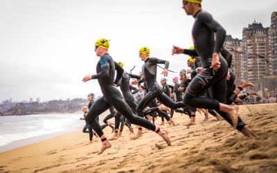 Männer rennen über den Strand ins Meer