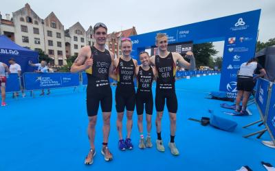 Zwei Frauen und zwei Männer posieren freudestrahlend nach EM-Bronze im Zielbereich des Triathlon-Kurses