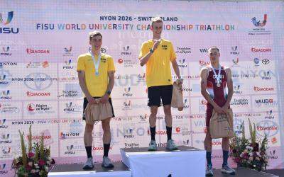 Drei junge Männer stehen auf dem Podium einer Triathlon-Veranstaltung