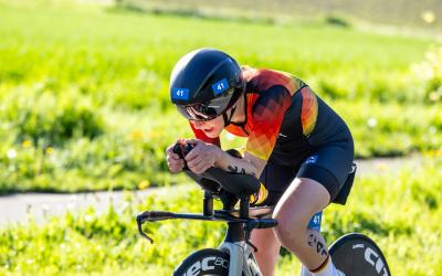 Eine Sportlerin fährt in geduckter Haltung Rennrad