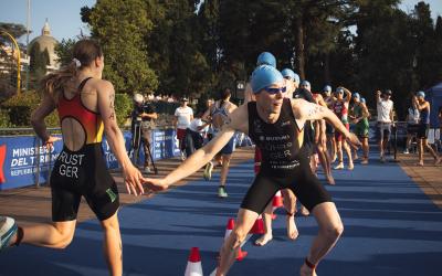 Eine Triathletin schlägt in einem Mixed-Staffel-Rennen mit dem nachfolgenden Triathleten ab