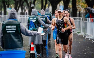 Mehrere Triathletinnen laufen an einer Wasser-Verpflegungsstelle vorbei